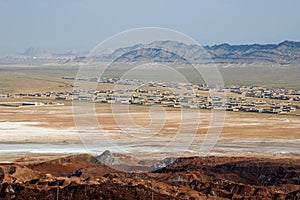 Salt crystals on brown earth and view of the city and mountains