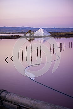 Salt farm excavator with sunset and a salt mountain