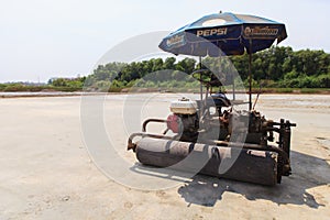 Salt farmers with car roller.