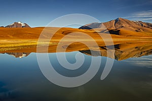 Salt lake Lejia reflection, idyllic volcanic landscape at Sunset, Atacama, Chile photo