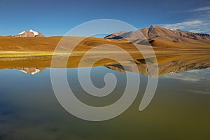 Salt lake Lejia reflection, idyllic volcanic landscape at Sunset, Atacama, Chile photo