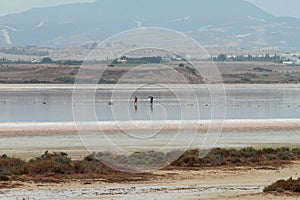Salt lake and photographer with model in middle. Larnaca, Cyprus
