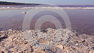 Salt lake, salt crystals. Salt water waves crash onto the shore in the self-precipitating salt of a salt lake. Kuyalnik Liman,