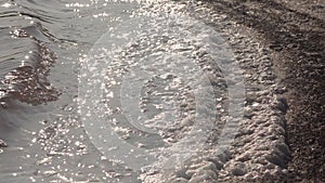 Salt lake, salt crystals. Salt water waves crash onto the shore in the self-precipitating salt of a salt lake. Kuyalnik Liman,