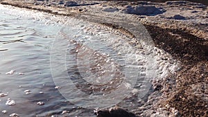 Salt lake, salt crystals. Salt water waves crash onto the shore in the self-precipitating salt of a salt lake. Kuyalnik Liman,