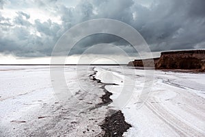 Salt lake surface under grey cloudy epic sky