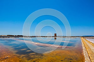 The salt pans of Trapani in the beautiful Italian region of Sicily in the summer, landscape with a tower