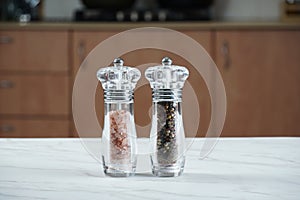 Salt and pepper grinders. Dried whole seed of black pepper and Himalayan pink salt
