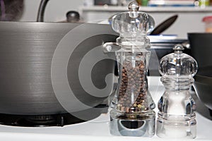 Salt and Pepper Grinders by Pots on a Gas Stove