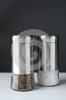 Salt and pepper shakers on white table, closeup