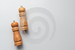 salt and pepper wooden shakers, grinders on a white table with white background