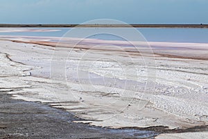 Salt pink lake surface with healing dirt, blue sky