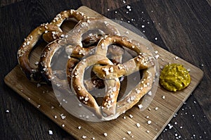 Salt Pretzels and Mustard on Rustic Dark Wood Table