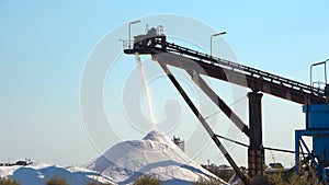 Salt production, conveyor belt with marine salt produced by the evaporation of seawater.