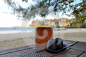 Salt shaker, pepper shaker and napkins on a wooden table on the sandy shore of a tropical island near the sea