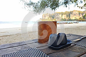 Salt shaker, pepper shaker and napkins on a wooden table on the sandy shore of a tropical island near the sea