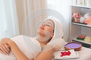 Salt spa massage relaxation concept. Beautiful woman lying down on the bed relax in spa salon with massage