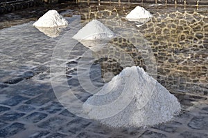 Salt stacks. Old-fashion production of salt with evaporation of seawater. Hard work under heat for an exceptional natural product