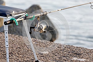 Salt water angling with rod beside a sea,