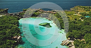 Salt water lake at sea bay with green cliff shore nature of Sumba Island, Indonesia aerial view