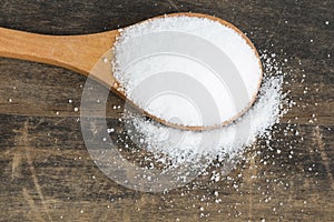 Salt in a Wooden Spoon on a Rustic Background