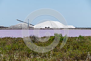 Salt works, industrial plant with white piles of Camagrue sea salt and pink salty lakes, Aigues-Mortes, Gard, Occitania region of