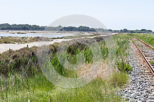 Salt works, industrial plant with white piles of Camagrue sea salt and pink salty lakes, Aigues-Mortes, Gard, Occitania region of