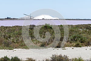 Salt works, industrial plant with white piles of Camagrue sea salt and pink salty lakes, Aigues-Mortes, Gard, Occitania region of