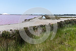 Salt works, industrial plant with white piles of Camagrue sea salt and pink salty lakes, Aigues-Mortes, Gard, Occitania region of