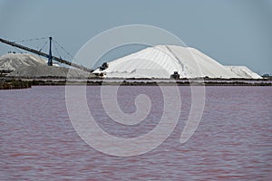 Salt works, industrial plant with white piles of Camagrue sea salt and pink salty lakes, Aigues-Mortes, Gard, Occitania region of