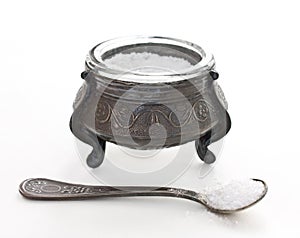 Saltcellar with spoon on white photo