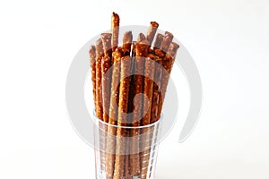 Salted Baked brown Pretzel Sticks in glass on white background,copy space,top view