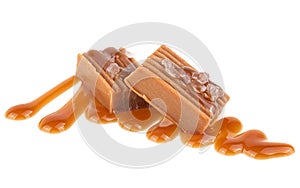 Salted caramel candies with caramel sauce isolated on white background. Toffee candies