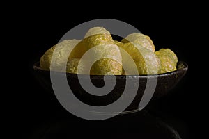 Salted corn puff isolated on black glass
