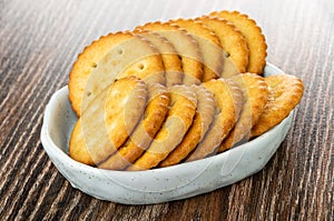 Salted crackers in bowl on wooden table