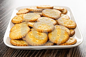 Salted crackers in plate on wooden table