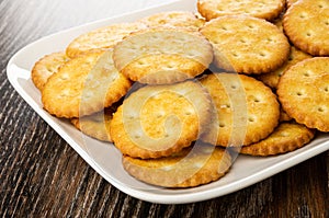 Salted crackers in white plate on wooden table