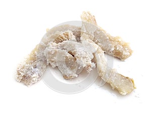 Salted flaked cod on white background. Pieces of Salted Fish Flakes. Closeup of a lot of salted cod ready for sale. Healthy eating