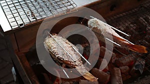 Salted Grilled fish rolling with charcoal stove with flame