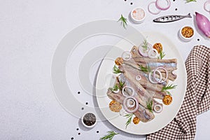 Salted herring with dijon mustard, dill and red onion rings on white stone background