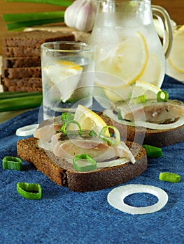 Salted herring with onion and lemon on a slice of bread