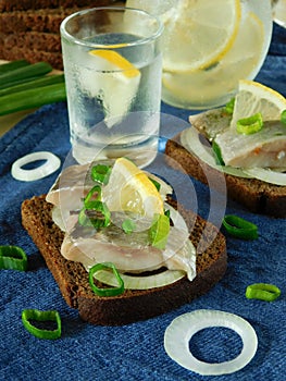 Salted herring with onion and lemon on a slice of bread