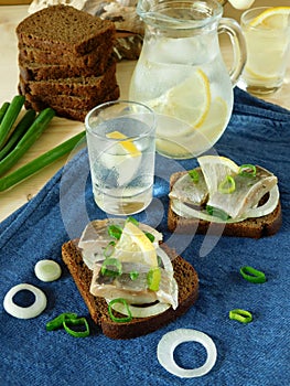 Salted herring with onion and lemon on a slice of bread