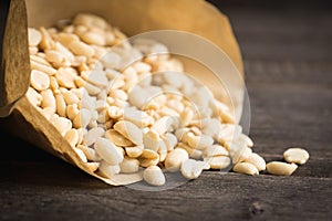 Salted peanuts in the vellum paper on rustic background