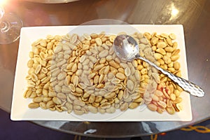 Salted peanuts in white dish stainless spoon for catering