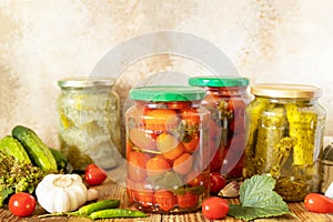 Salted pickled cucumbers and tomatoes preserved canned in glass jar. Home economics, autumn