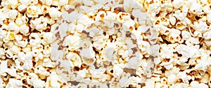 Salted popcorn background or texture, close-up, top view banner