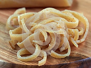 Salted raw pork rind strips set on a wooden board