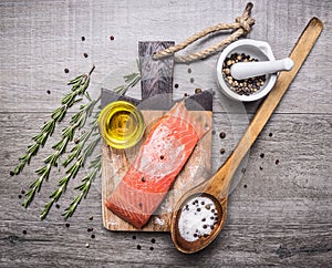 Salted salmon fillet on a cutting board with delicious ingredients for cooking wooden rustic background top view