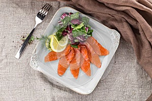 Salted salmon with salad and lemon on white plate on the table